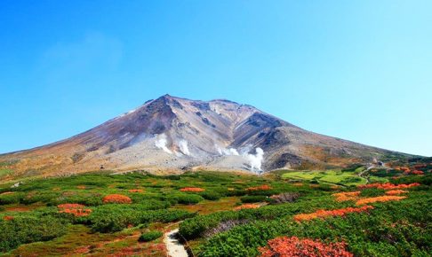 噴煙を上げる山頂付近の山肌と鮮やかな紅葉のコントラストが美しい旭岳