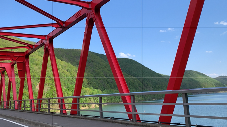 湖とダムをまたぐ赤い橋