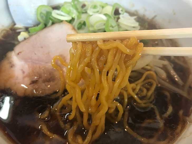 黒い醤油スープで黄色い麺が黒く染まる